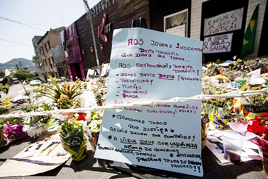 Cartazes em meio s flores em frente da boate Kiss pede justia aos "jovens inocentes"