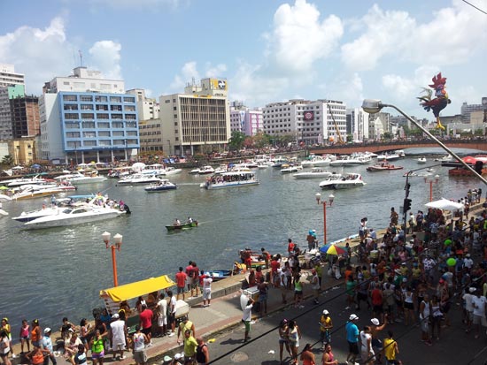 Em lanchas, folies assitem desfile do bloco Galo da Madrugada no rio Capibaripe, em Recife (PE) 