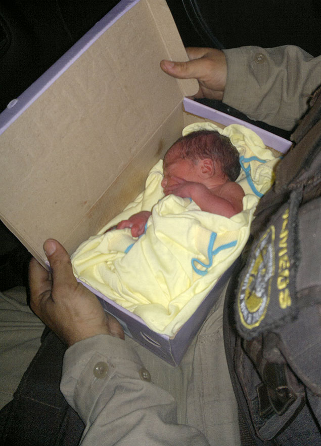 Bebê dentro da caixa de sapatos em que foi encontrado, numa parada de ônibus em Salvador (BA)