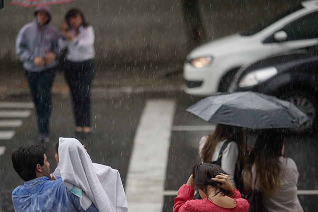Pedestres caminham em meio a chuva forte na regio da Lapa, zona oeste de So Paulo