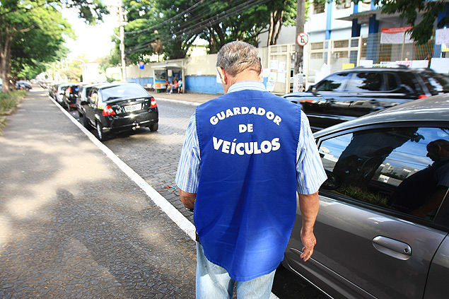O flanelinha Waldemar Ferreira olha carros na avenida Nove de Julho, em Ribeiro Preto