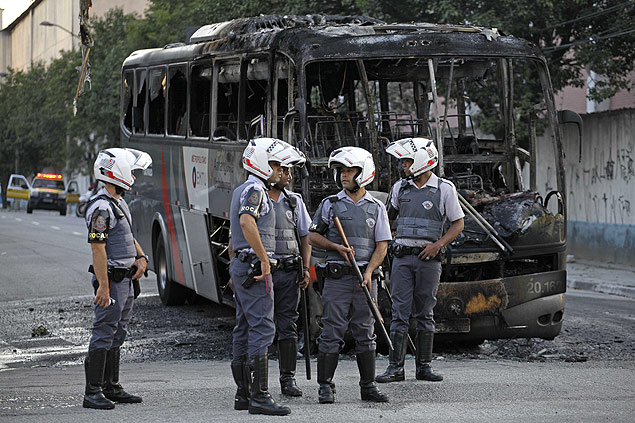 Grupo queima nibus aps duas pessoas serem detidas por tentativa de assalto a PM; houve confronto entre policiais e moradores