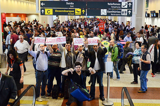 Grupo de passageiros no aeroporto Santos Dumont, no Rio, protesta com cartazes escrito: "Dilma, imagina na Copa"