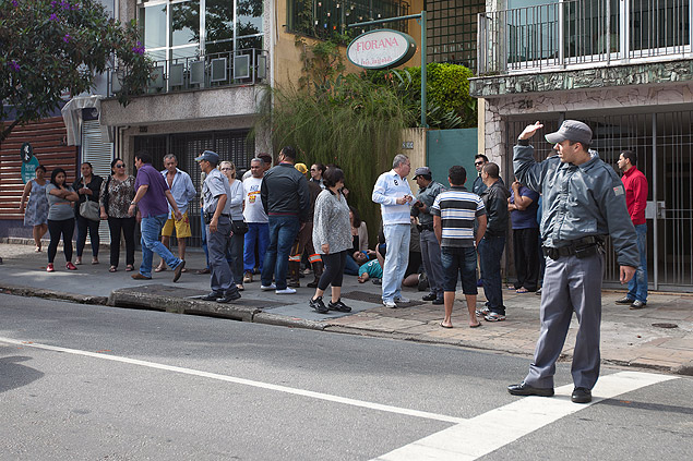 Vtima (de camiseta azul) deitada no cho na alameda Joaquim Eugnio de Lima; homem foi atingido em suposta troca de tiros 
