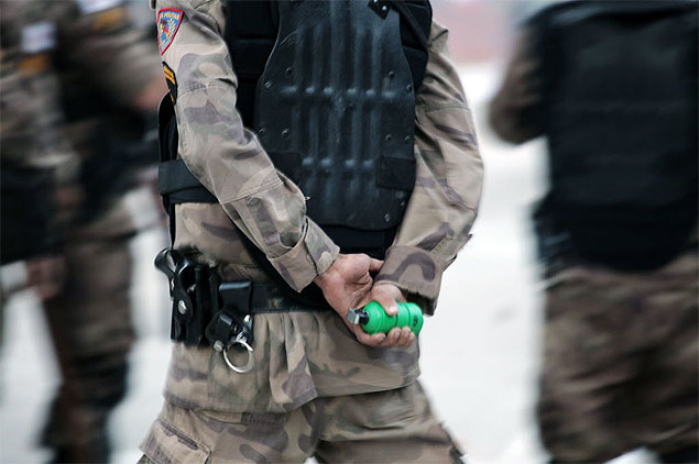 Policial segura bomba de gs lacrimogneo durante protesto em Belo Horizonte, Minas Gerais