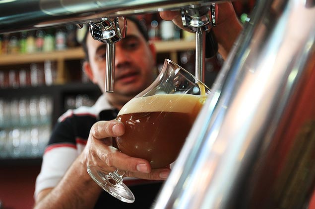 O gerente da Invicta, Emerson Caccia, tira chope na cervejaria artesanal, que foi fundada em 2011 em Ribeirão Preto