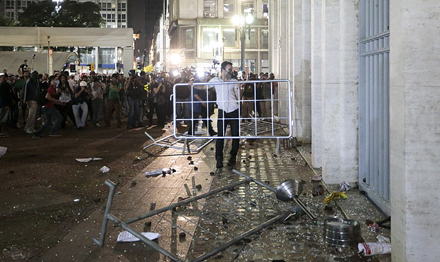 Manifestante identificado como Tiago usa grade para quebrar os vidros da prefeitura; polícia está em busca do jovem