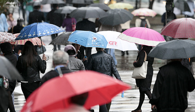 Pessoas caminham com guarda-chuvas pela regio da avenida Paulista, na regio central de So Paulo