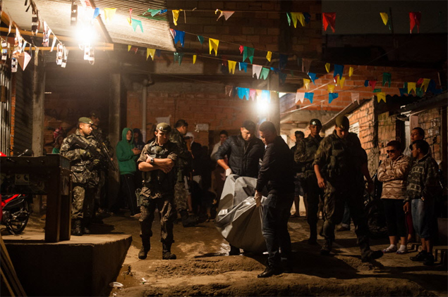 Policiais militares carregam corpo de suspeito morto em favela no Parque da Mooca, zona leste de So Paulo