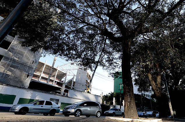 Carro passa  sombra das rvores do canteiro central da av. Francisco Matarazzo, em frente  obra do novo estdio do Palmeiras