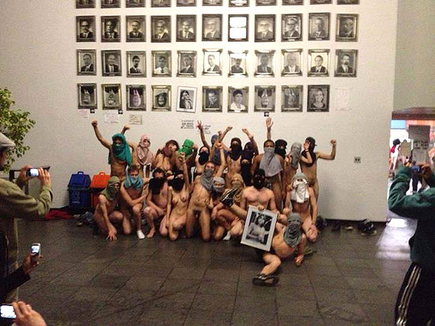 Manifestantes nus tiram fotos em frente à galeria de ex-presidentes da Câmara Municipal de Porto Alegre antes de deixar o prédio
