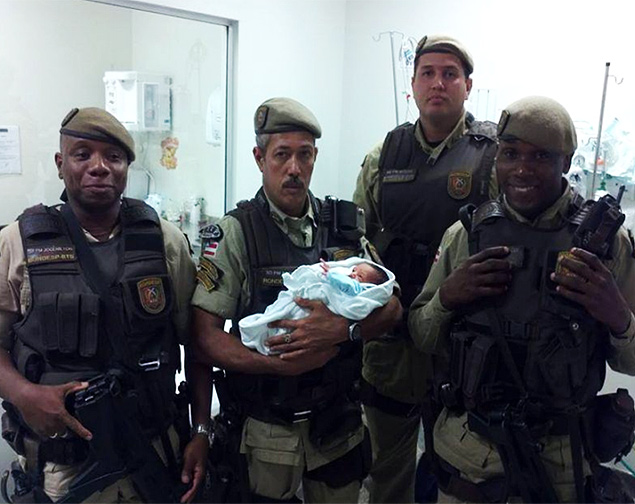 Policiais posam com beb encontrado numa caixa de sapato em Salvador; criana est sendo chamada de Francisco, em homenagem ao papa