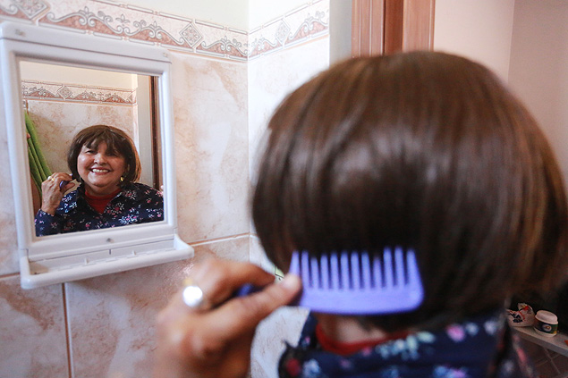 Joselice Rosa da Cruz, 62, ajeita a peruca sinttica fornecida pelo HC