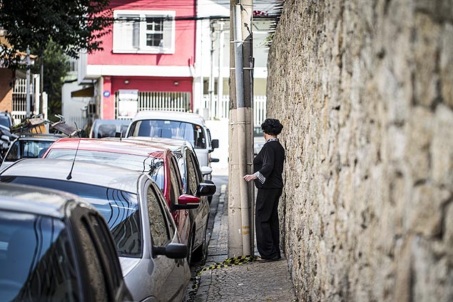 Pedestre se espreme entre muro e poste da rua Romilda Margarida Gabriel, no Itaim Bibi