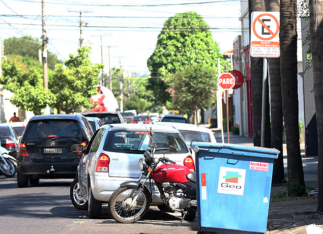 Carro e moto parados em frente a uma placa de proibido estacionar na rua Eliseu Guilerme, regio nobre de Ribeiro Preto
