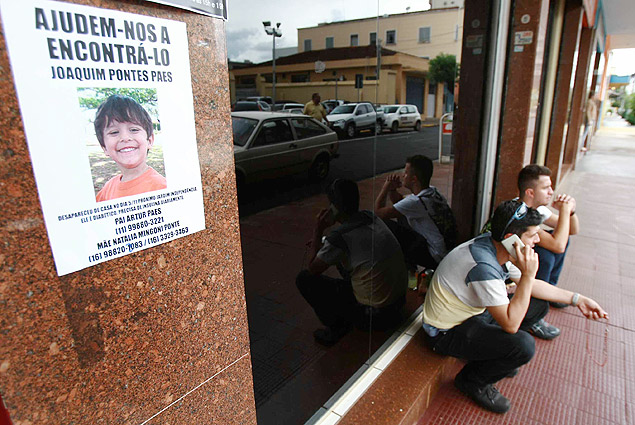 Arthur Paes, pai do menino desaparecido Joaquim Ponte Marques, fala pelo telefone celular em frente  delegacia de Ribeiro Preto