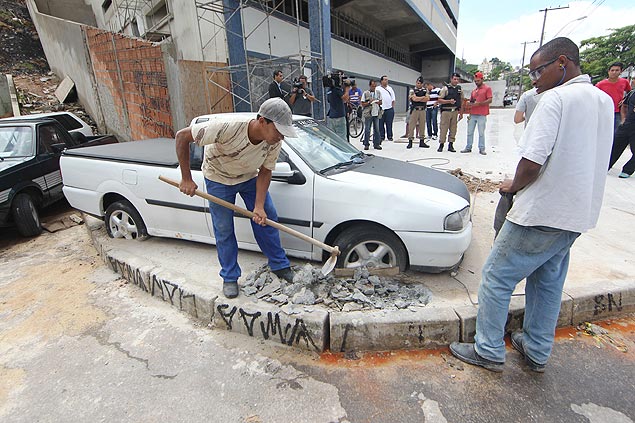 Operrios retiram concreto em volta do carro aps disputa entre vizinhos em Belo Horizonte