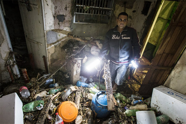 Pintor João Cecílio Passos observa sujeira acumulada em sua casa após alagamento no Jardim Maria Sampaio