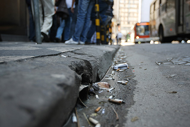Bitucas jogadas no chão se acumulam em sargeta na praça da República, no centro de São Paulo.