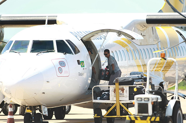 Funcionários da Passaredo embarcam bagagens em avião no aeroporto Leite Lopes, em Ribeirão Preto