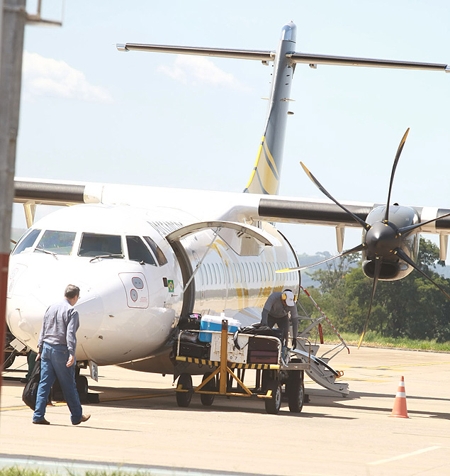Funcionrios da Passaredo embarcam bagagens em avio no aeroporto Leite Lopes, em Ribeiro Preto