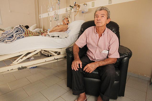 Tadeu Ferreira, 69, na Santa Casa de Barretos, ao lado da cama do filho Jivanei