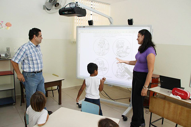 Marcelo Barbieri, prefeito de Araraquara, observa professora e alunos com lousa digital