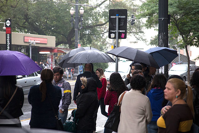 Pedestres se protegem de garoa na tarde mais fria do ano na capital paulista; temperatura chegou a 14,8C