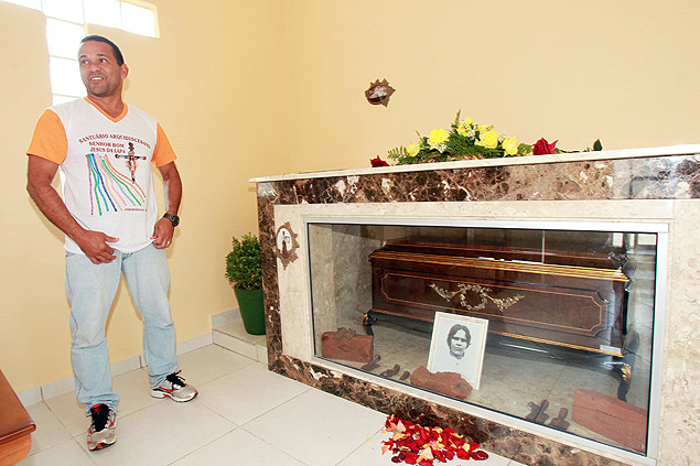 O padre Ilson Vicente ao lado dos restos mortais da religiosa Pequena em capela de Jardinpolis