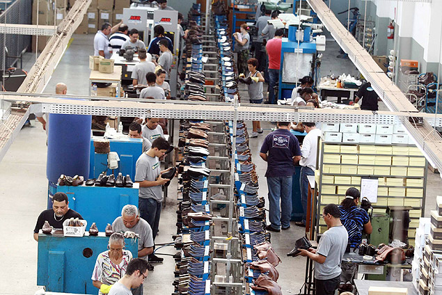 Funcionrios trabalham em linha de produo de fbrica de calados de Franca