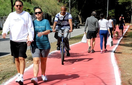 AO lado de ciclista, pedestres caminham na ciclovia da av. Sumar antes da inaugurao