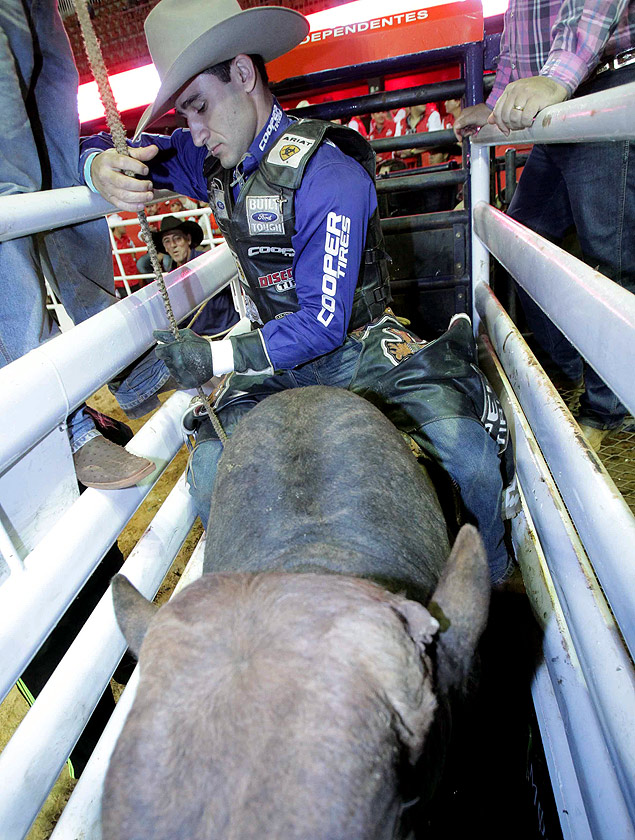 O peo Joo Ricardo Vieira da Silva se prepara para montar em touro no rodeio de Barretos