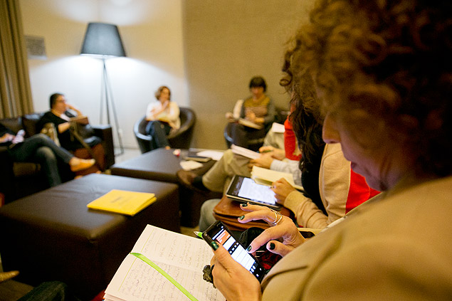 Aluna usa smartphone durante aula em curso de escrita; mania pegou entre os adultos