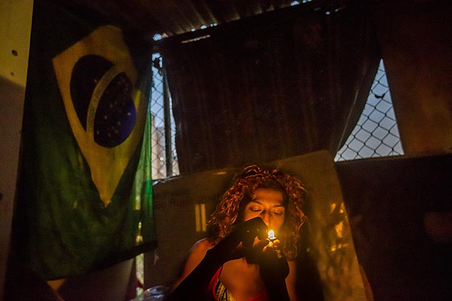 A moradora de rua Evelyn, 23, fuma crack dentro de barraco, na cracolndia