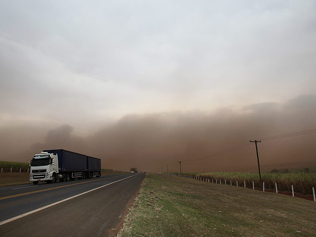 Caminho trafega por rodovia em meio a nuvem de poeira na regio de Ribeiro Preto