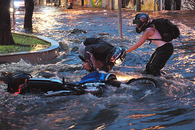 Motociclista cai durante chuva e alagamento nesta segunda-feira (22), na Rua Turiassu em So Paulo. 