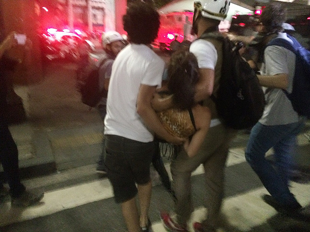 Manifestante sendo carregada por companheiros