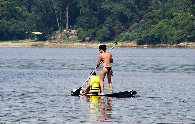 Mulher faz 'stand-up paddle' na represa do Guarapiranga neste sbado ensolarado
