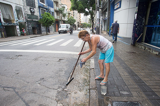 A faxineira Maria Helena Zuim, 66, usa para limpeza de loja em que trabalha a 'água da guia