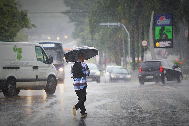 Pedestre caminha sob a chuva em Pinheiros; tempo continuar instvel at o final da semana