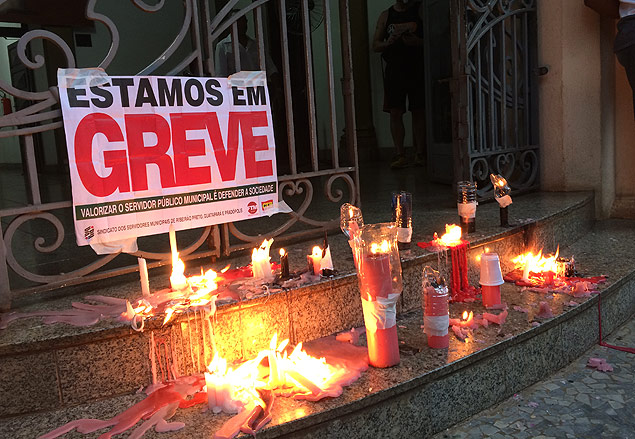 Servidores de Ribeiro Preto (SP) em greve acendem velas rosas, a cor preferida da prefeita Drcy Vera (PSD), simbolizando o "luto" da categoria 