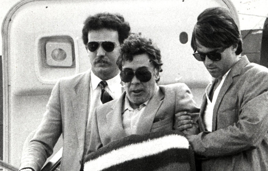 O italiano Tommaso Buscetta aparece saindo escoltado de um avio no aeroporto Fiumicino, em Roma (Itlia) 