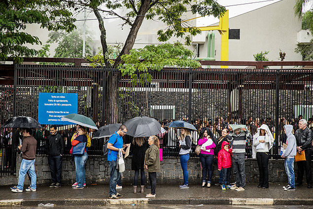 Debaixo de chuva, brasileiros enfrentam fila para retirar documento amerciano 