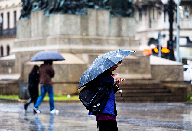 Pedestres se protegem da chuva na regio central de So Paulo