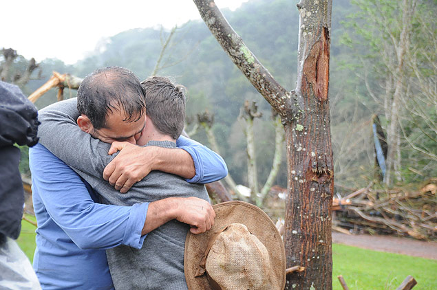 O agricultor Clairton Lauxen abraa o filho Bruno, 13; famlia se refugiou em rvores para sobreviver a enchente