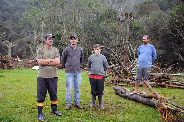 O agricultor Alexandre Lauxen (segundo da esq. para a dir.) e seus familiares; eles se amarraram a rvores para se proteger das chuvas em SC