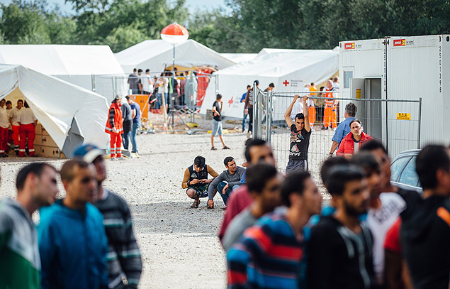 Refugiados so vistos na entrada de organizao que recepciona quem busca asilo em Dresden