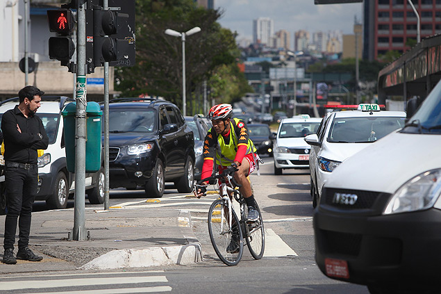 Em outro cruzamento da avenida, ciclista no respeita sinal dos carros e avana no trnsito