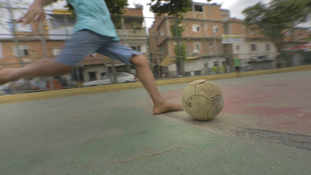 Criana joga futebol na favela da Mar, no Rio de Janeiro; reportagem presenciou tiroteio