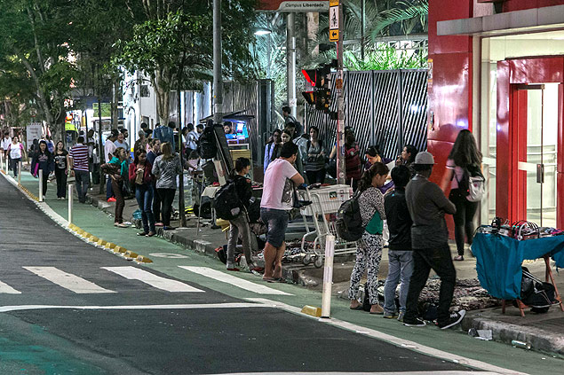 Vendedores ambulantes e clientes ocupam faixa verde reservada a pedestres na avenida Liberdade, em SP
